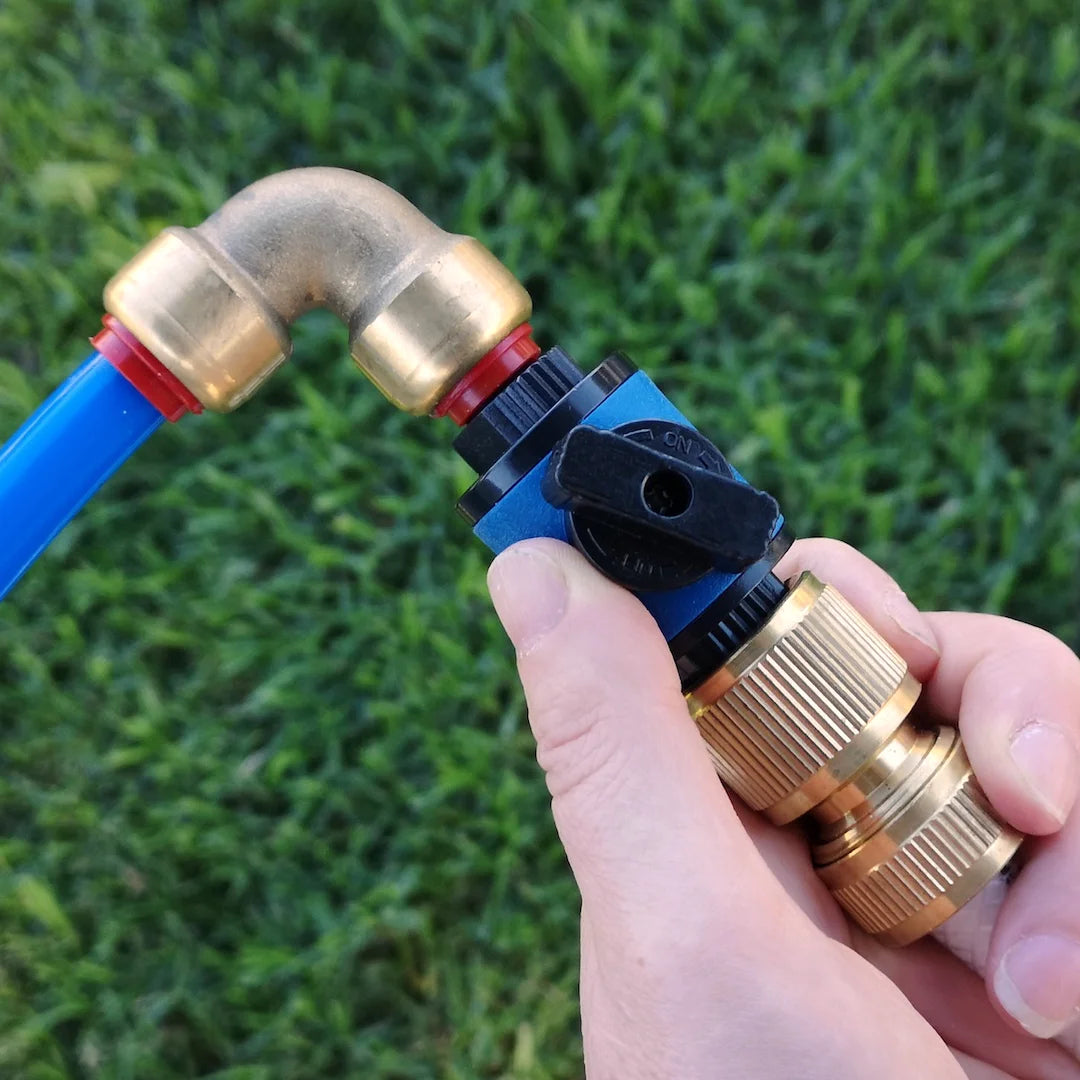 A close-up view of an inline tap that's attached to a brass elbow fitting and blue 12mm diameter water hose